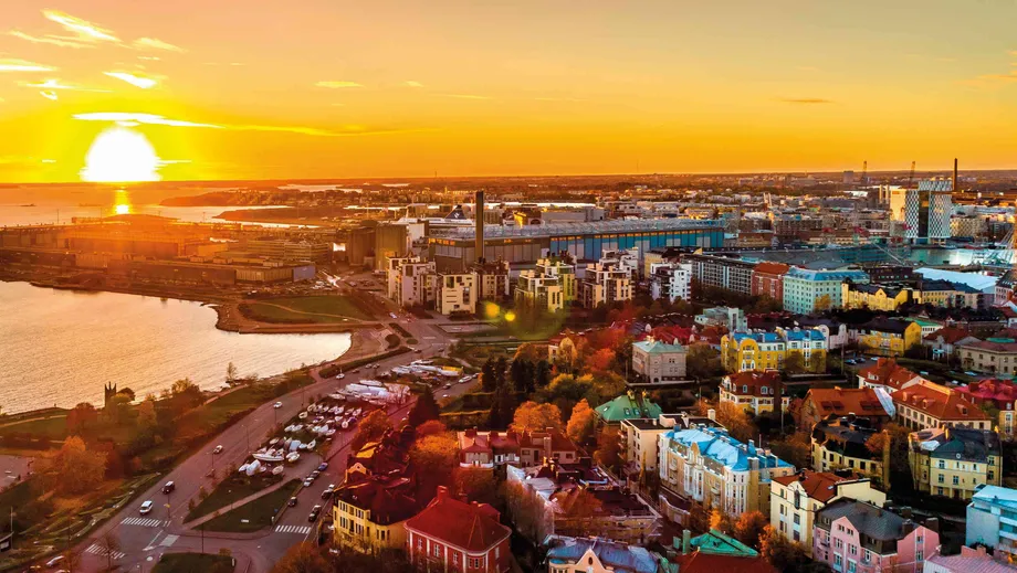 taloyhtiöiden kattoja kaupunkimaisemassa auringonlaskussa. Taloyhtiön kattoremontteja meneillään. 